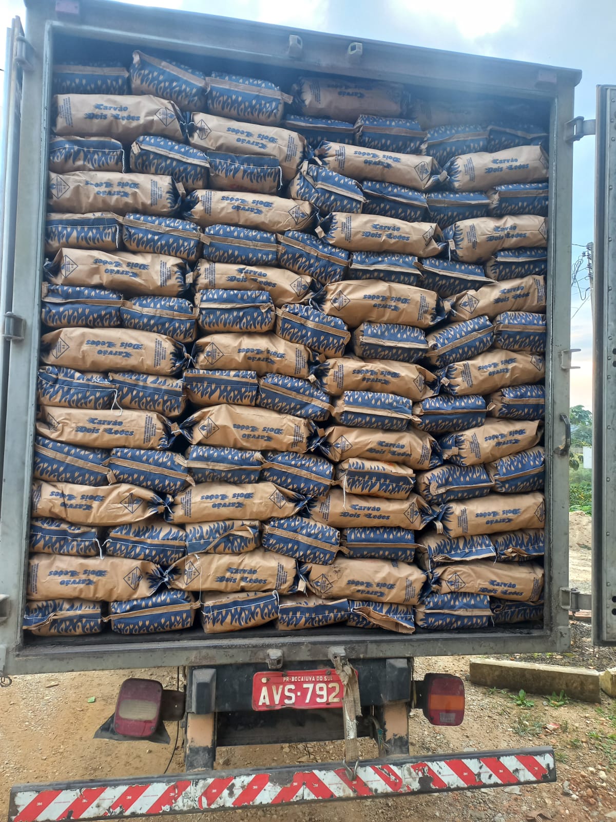 Caminhão carregado com sacos de carvão Dois Leões para entrega
